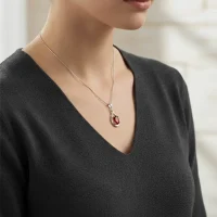 model wearing silver pendant with 5x7 mm oval shaped garnet