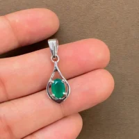 silver pendant with 5x7 mm oval shaped green onyx displayed on hand