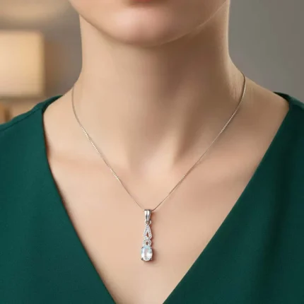 model wearing silver pendant with 5x7 mm oval rainbow moonstone