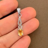 silver pendant with 5x7 mm oval citrine displayed on hand