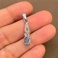 silver pendant with 5x7 mm oval labradorite displayed on hand