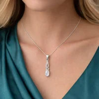model wearing silver pendant with 5x7 mm oval rainbow moonstone cabochon