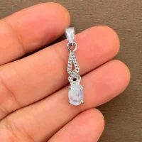 silver pendant with 5x7 mm oval rainbow moonstone cabochon displayed on hand