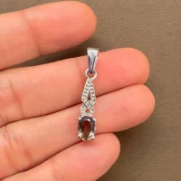 silver pendant with 5x7 mm oval smoky quartz displayed on hand