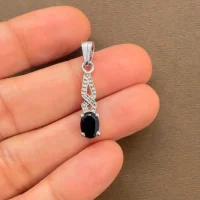 silver pendant with 5x7 mm oval black onyx displayed on hand