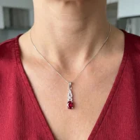model wearing silver pendant with 5x7 mm oval garnet