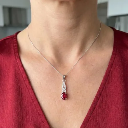 model wearing silver pendant with 5x7 mm oval garnet