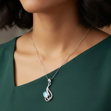 model wearing silver pendant with 5x7 mm oval rainbow moonstone