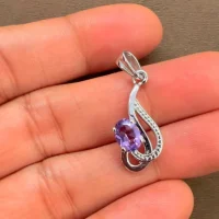 silver pendant with 5x7 mm oval brazilian amethyst displayed on hand