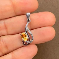 silver pendant with 5x7 mm oval citrine displayed on hand