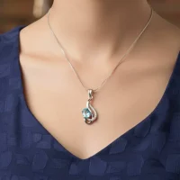 model wearing silver pendant with 5x7 mm oval blue topaz
