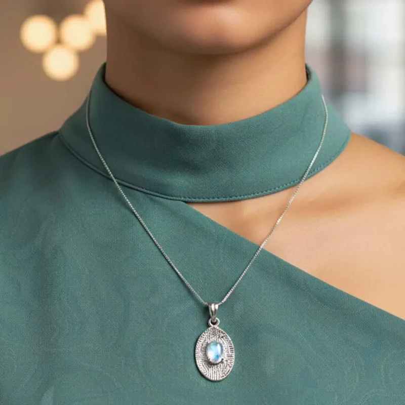 model wearing silver pendant with 5x7 mm oval rainbow moonstone