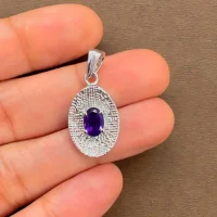 silver pendant with 5x7 mm oval amethyst displayed on hand