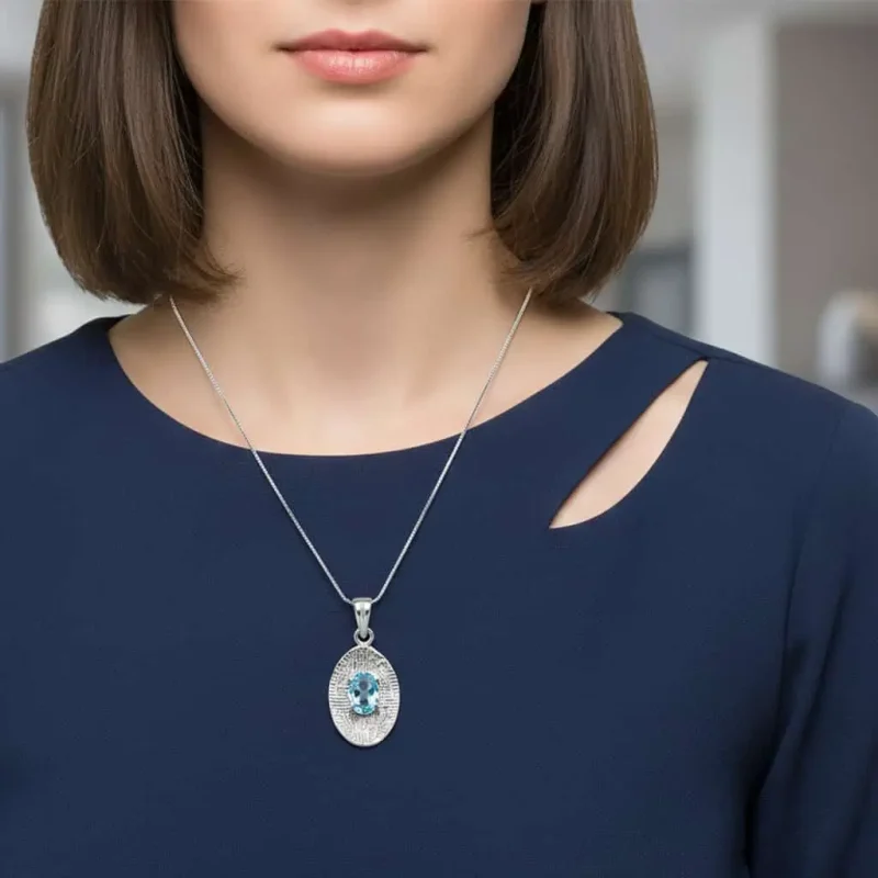 model wearing silver pendant with 5x7 mm oval blue topaz