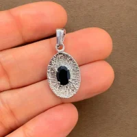 silver pendant with 5x7 mm oval black onyx displayed on hand