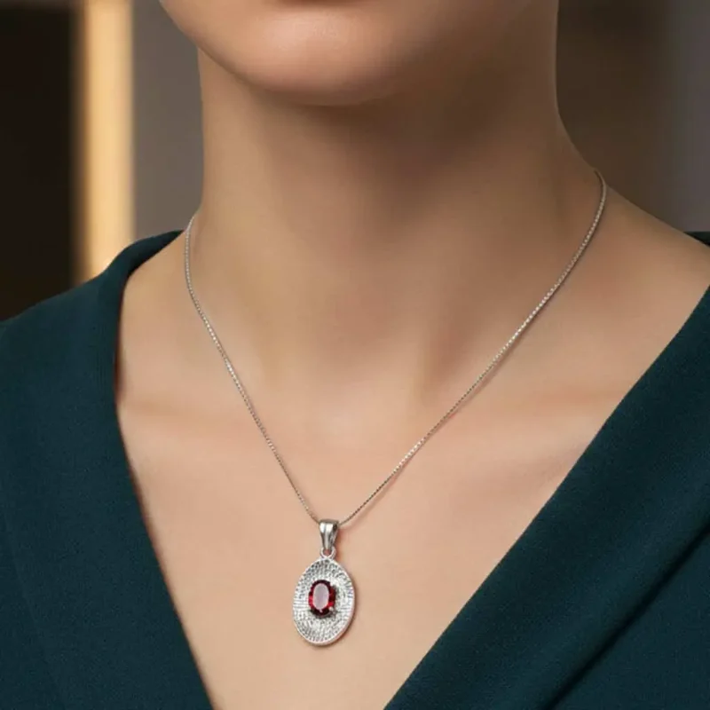 model wearing silver pendant with 5x7 mm oval garnet