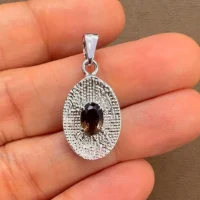 silver pendant with 5x7 mm oval smoky quartz displayed on hand