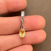 silver pendant with 5x7 mm oval citrine displayed on hand