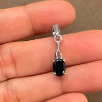 silver pendant with 5x7 mm oval black onyx displayed on hand