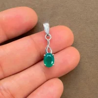 silver pendant with 5x7 mm oval green onyx displayed on hand