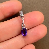 silver pendant with 5x7 mm oval amethyst displayed on hand