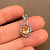 silver pendant with 5x7 mm oval citrine displayed on hand
