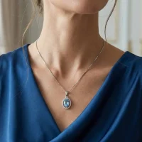 model wearing silver pendant with 5x7 mm oval blue topaz