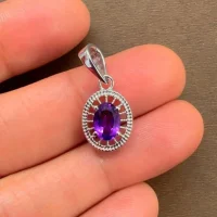 silver pendant with 5x7 mm oval amethyst displayed on hand