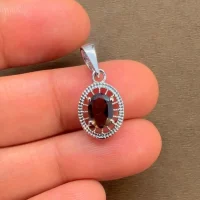 silver pendant with 5x7 mm oval smoky quartz displayed on hand