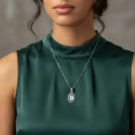 model wearing silver pendant with 5x7 mm oval rainbow moonstone