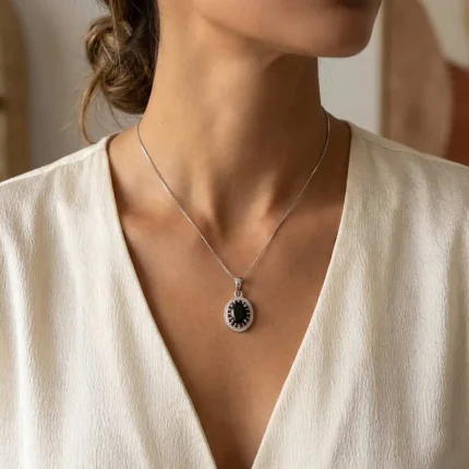 model wearing silver pendant with 5x7 mm oval black onyx