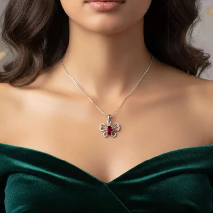 model wearing silver pendant butterfly shaped with 5x7 mm oval garnet