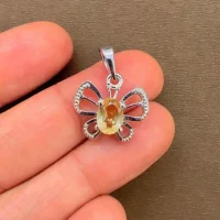 silver pendant butterfly shaped with 5x7 mm oval citrine displayed on hand
