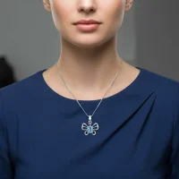 model wearing silver pendant butterfly shaped with 5x7 mm oval blue topaz