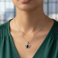 model wearing silver pendant butterfly shaped with 5x7 mm oval black onyx