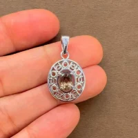 silver pendant with 5x7 mm oval smoky quartz displayed on hand