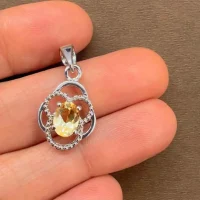 silver pendant with 5x7 mm oval citrine displayed on hand