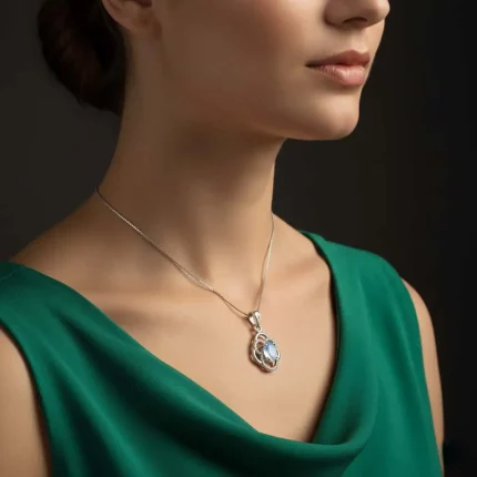 model wearing silver pendant with 5x7 mm oval rainbow moonstone