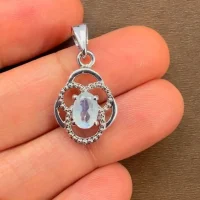 silver pendant with 5x7 mm oval rainbow moonstone displayed on hand