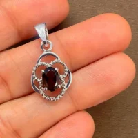 silver pendant with 5x7mm oval smoky quartz displayed on hand