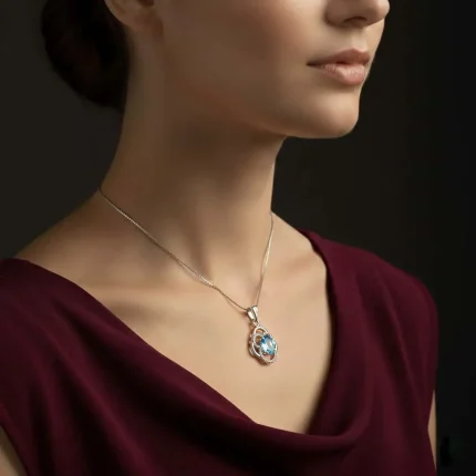 model wearing silver pendant with 5x7 mm oval blue topaz