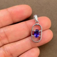 silver pendant with 5x7 mm oval amethyst displayed on hand