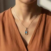 model wearing silver pendant with 5x7 mm oval labradorite