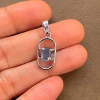 silver pendant with 5x7 mm oval labradorite displayed on hand