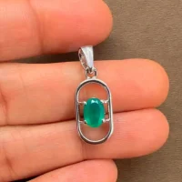 silver pendant with 5x7 mm oval green onyx displayed on hand