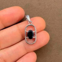silver pendant with 5x7 mm oval black onyx displayed on hand