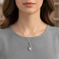 model wearing silver pendant with 5x7 mm oval rainbow moonstone