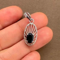 silver pendant with 5x7 mm oval black onyx displayed on hand