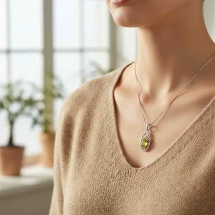 model wearing silver pendant with 5x7 mm oval peridot