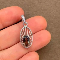 silver pendant with 5x7 mm oval smoky quartz displayed on hand